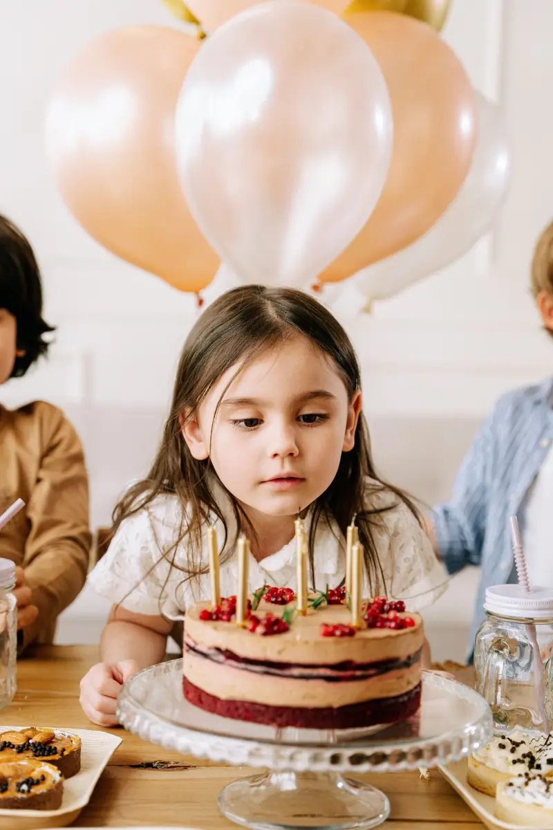 Girl looking at a birthday cake with candles