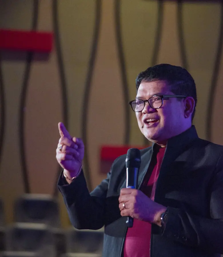 Speaker presenting on stage at a corporate event