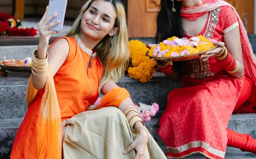Friend taking a selfie next to a woman holding a plate of flowers