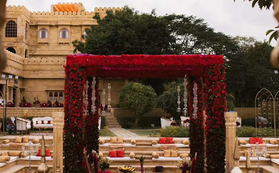 Red flower mandap set up in the courtyard of a fort